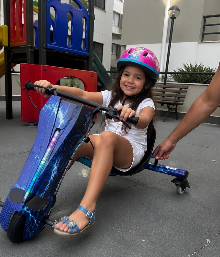 Cliente mirim de capacete no patinete drift no playground